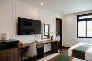 a bedroom with a desk with a television and a bed at AS Hotel Đà Lạt in Da Lat