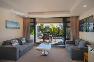ネルソンにあるThe Sands Beach Apartmentのソファとテーブルのあるリビングルーム +18枚の写真