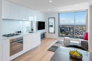 een witte keuken met uitzicht op de stad bij Imagine Marco in Melbourne