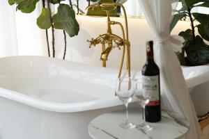 a bottle of wine and two wine glasses on a table at AMIGO Luxury Palace- Cạnh Chợ Đêm Đà Lạt in Da Lat +67 photos