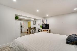 a bedroom with a white bed and a kitchen at Cozy Studio Retreat in Salt Lake City Area! in Magna