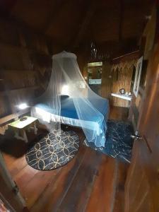 a bedroom with a bed with a mosquito net at Tia's Bamboo Cottages Restaurant, Bar & Sulphur Spa in Roseau