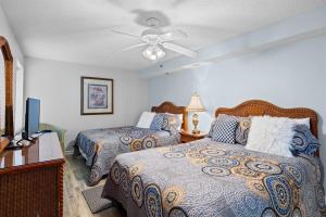 a bedroom with two beds and a ceiling fan at Oceanfront Crescent Shores #208-Sleeps 10 3bed 3bath 28 Foot Balcony in North Myrtle Beach +53 photos