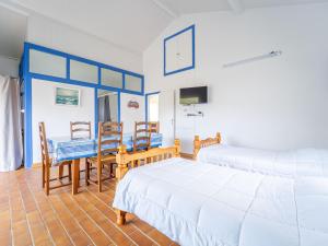 a bedroom with two beds and a table and chairs at Maison de vacances à Lit-et-Mixe pour 4 pers. - Calme et nature avec jardin inclus - FR-1-50-176 in Lit-et-Mixe
