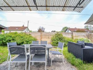 a patio with a table and chairs and a fence at Maison de vacances à Lit-et-Mixe pour 4 pers. - Calme et nature avec jardin inclus - FR-1-50-176 in Lit-et-Mixe