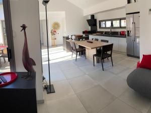 a kitchen and living room with a table and chairs at Maison de vacances à Mimizan Plage - Confort moderne proche océan - FR-1-50-177 in Mimizan