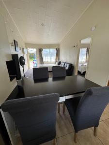 a living room with a black table and chairs at Fountain Court Motel in Tauranga