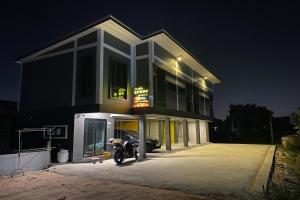 a motorcycle parked in front of a building at night at Baan Pak Sud Soi in Ban Rai