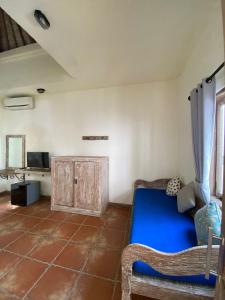 a room with a blue bed and a cabinet at Mango 5 Hotel in Amed