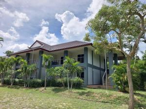 a house with palm trees in front of it at Sisina Resort in Ban Krut