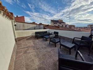 a balcony with chairs and tables on a roof at El peromato in Zamora