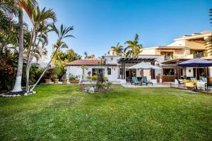 a house with a yard with palm trees at Magnificent Canal House with Dock and Adjacent Golf in Nuevo Nayarit