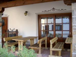 a patio with benches and a table and a window at AGRITURISMO Casa Riz in Cormòns