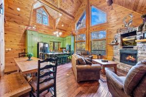 a living room with a fireplace in a log cabin at Relaxation Retreat - Pickleball Cabin - Wi-Fi, Fire Pit with Bar, EV, Game Room, Hot Tub, Pool Access - Mins to PF in Sevierville