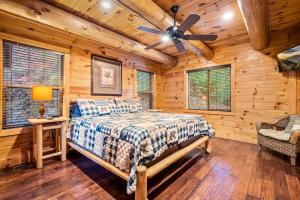 a bedroom with a bed and a ceiling fan at Relaxation Retreat - Pickleball Cabin - Wi-Fi, Fire Pit with Bar, EV, Game Room, Hot Tub, Pool Access - Mins to PF in Sevierville