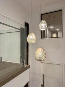 two lights hanging over a sink in a bathroom at Beachfront Getaway in Torquay