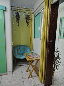 a room with a table and a blue chair at Ganesha HOSTAL in Mexico City +11 photos