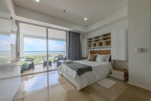 a bedroom with a large bed and a large window at Cartagena Beach Resort 1133 in Cartagena de Indias