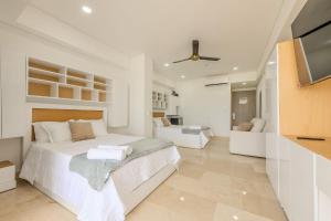 a white bedroom with a bed and a tv at Cartagena Beach Resort 1133 in Cartagena de Indias
