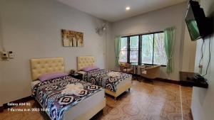 une chambre avec deux lits et un bureau et une fenêtre dans l'établissement Huaykhakhaeng Country Home Resort, à Ban Rai