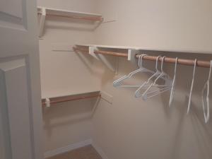 a walk in closet with white walls and wooden hangers at Great place for good night rest in Anaheim