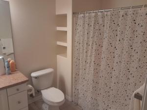a bathroom with a toilet and a shower curtain at Great place for good night rest in Anaheim