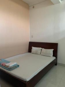 un lit avec des draps blancs et des oreillers dans une chambre dans l'établissement Minh Anh Homestay Huế, à Ấp Long Hồ Hạ