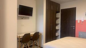 - une chambre avec un bureau avec deux chaises et un lit dans l'établissement Studio Coral en la mejor Zona de Cochabamba, à Cochabamba