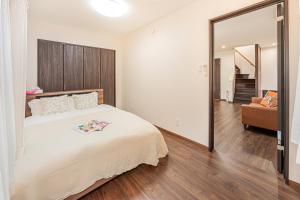 a bedroom with a large white bed and a couch at 華夏民宿 in Tokyo