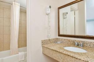 a bathroom with a sink and a mirror and a tub at Americas Best Value Inn Elizabethtown in Elizabethtown +25 photos