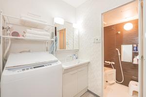 a white bathroom with a sink and a toilet at 華夏民宿 in Tokyo +53 photos
