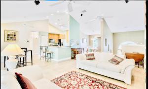 ein Wohnzimmer mit weißen Möbeln und eine Küche in der Unterkunft Amazing Waterfront Apt near Disney and Lake Tohoa in Kissimmee