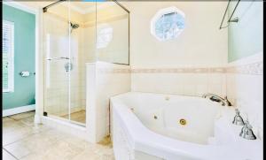 ein weißes Badezimmer mit Badewanne und Dusche in der Unterkunft Amazing Waterfront Apt near Disney and Lake Tohoa in Kissimmee + 62 Fotos