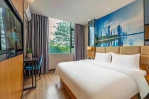 a hotel room with a large bed and a desk at Chonpines Hotel North Xiamen Station Jimei University in Xiamen