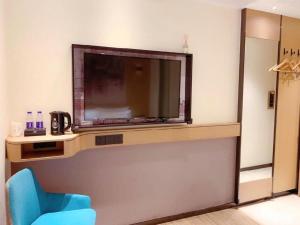 a room with a blue chair and a large television at City Comfort Inn Shenzhen Exhibition Center North Huaqiang Metro Station in Shenzhen