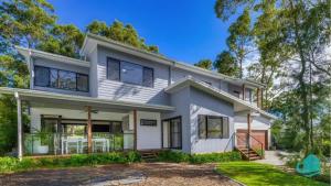 una gran casa blanca con árboles en Lake Breeze - lakeside, bushland escape, with plunge pool, en Cams Wharf