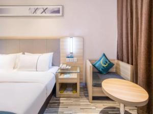 a hotel room with a bed and a table at City Comfort Inn Deyang Wenmiao Square Gymnasium in Deyang +16 photos