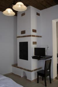 Habitación con chimenea, escritorio y TV. en Pékapartman, en Kőszeg