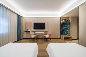 a hotel room with two beds and a table and chairs at City Comfort Inn Huanggang Wuxue Bus Center in Wuxue