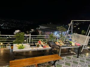 a table with food on a balcony at night at Villa Đường Mây 2 in Tam Ðảo