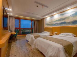 a hotel room with two beds and a desk at Shell Hotel Changzhou North Railway Station Global Harbor Metro Station in Changzhou +42 photos