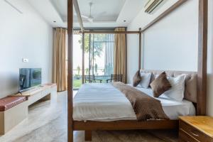 a bedroom with a canopy bed and a television at Heartland- Ganga Villa with Jacuzzi and private lift in Rishīkesh
