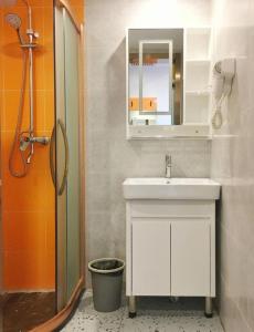 une salle de bain avec un lavabo, un miroir et une douche dans l'établissement Shell Hotel Beijing Miyun District Shuiku Yangguang, à Xiwengzhuang