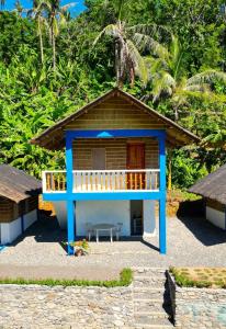 a small building with a porch and a table at L'Astrolabe - Riverside Bungalow with Sea View in Baras