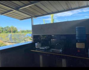 a kitchen counter with a sink and a large window at Kian and Kayden's private pool and guesthouse in Sampong