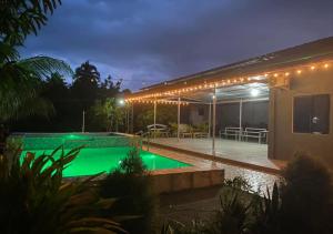 a house with a green swimming pool at night at Kian and Kayden's private pool and guesthouse in Sampong