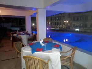 a restaurant with a table and a swimming pool at Sapphire Hotel in Kampala