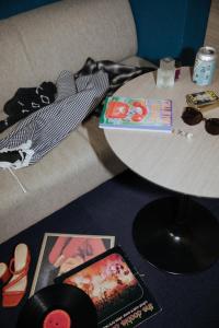 a couch with a table with a cd and other items at Hotel She, Osaka in Osaka +41 photos