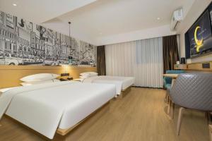 a hotel room with two beds and a desk at City Comfort Inn Wuzhou Sun Plaza Wanda in Wuzhou +184 photos