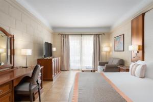 a hotel room with a bed and a living room at Kempinski Hotel San Lawrenz in San Lawrenz